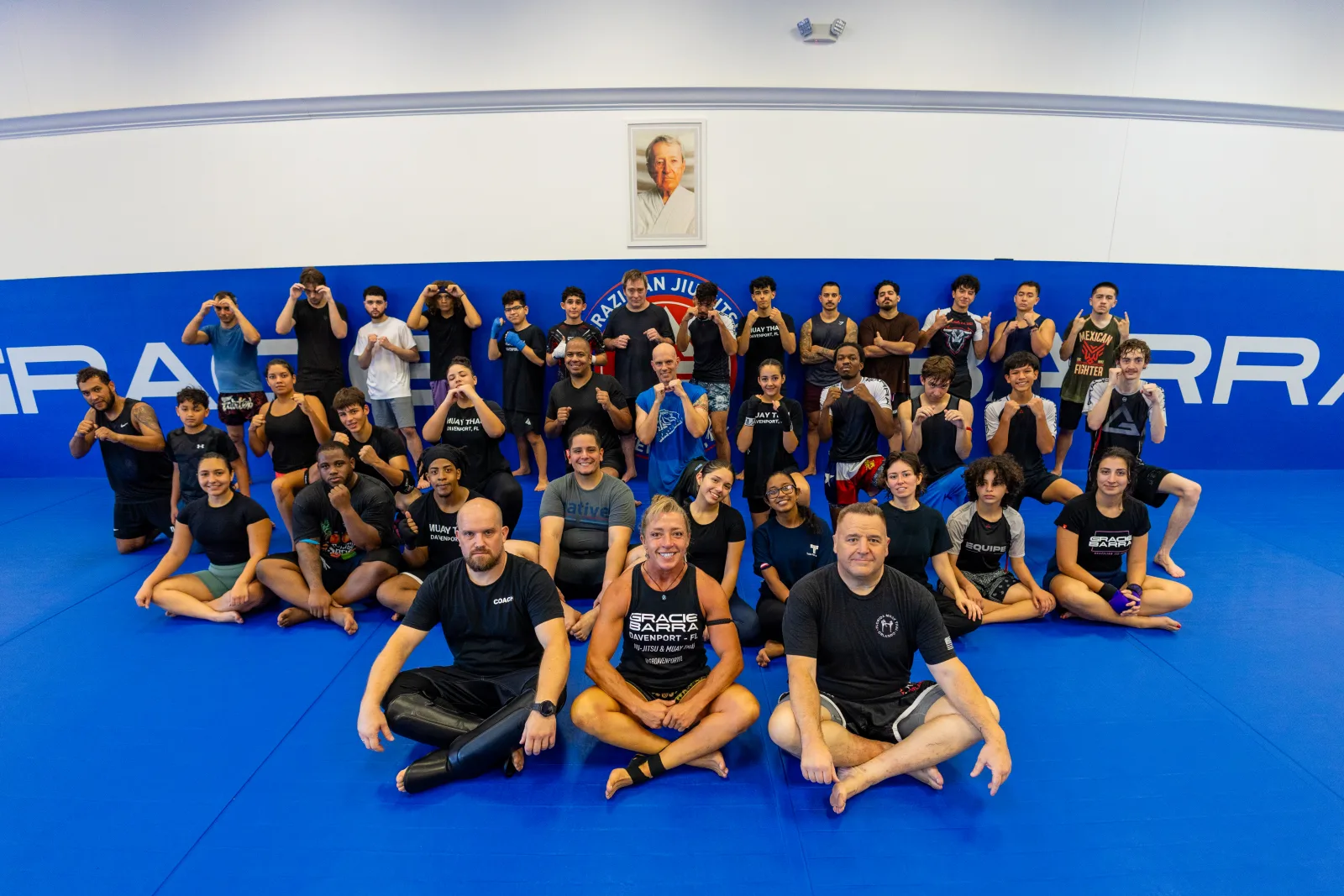 Muay Thai class group photo at Gracie Barra Davenport with three coaches and a full team of students